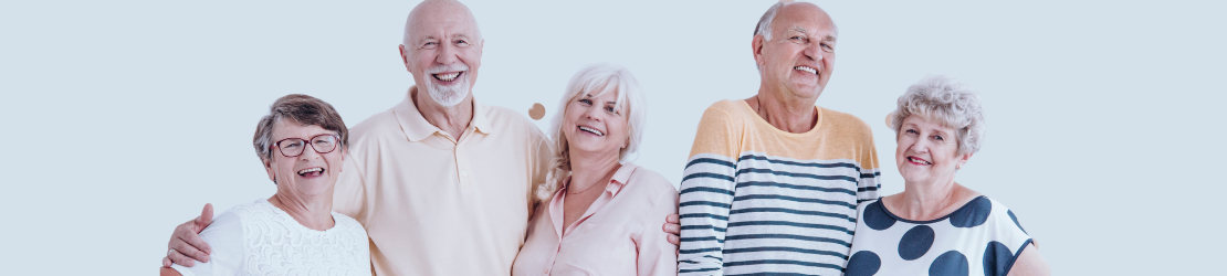 Grupa uśmiechniętych seniorów i seniorek pozuje do zdjęcia.